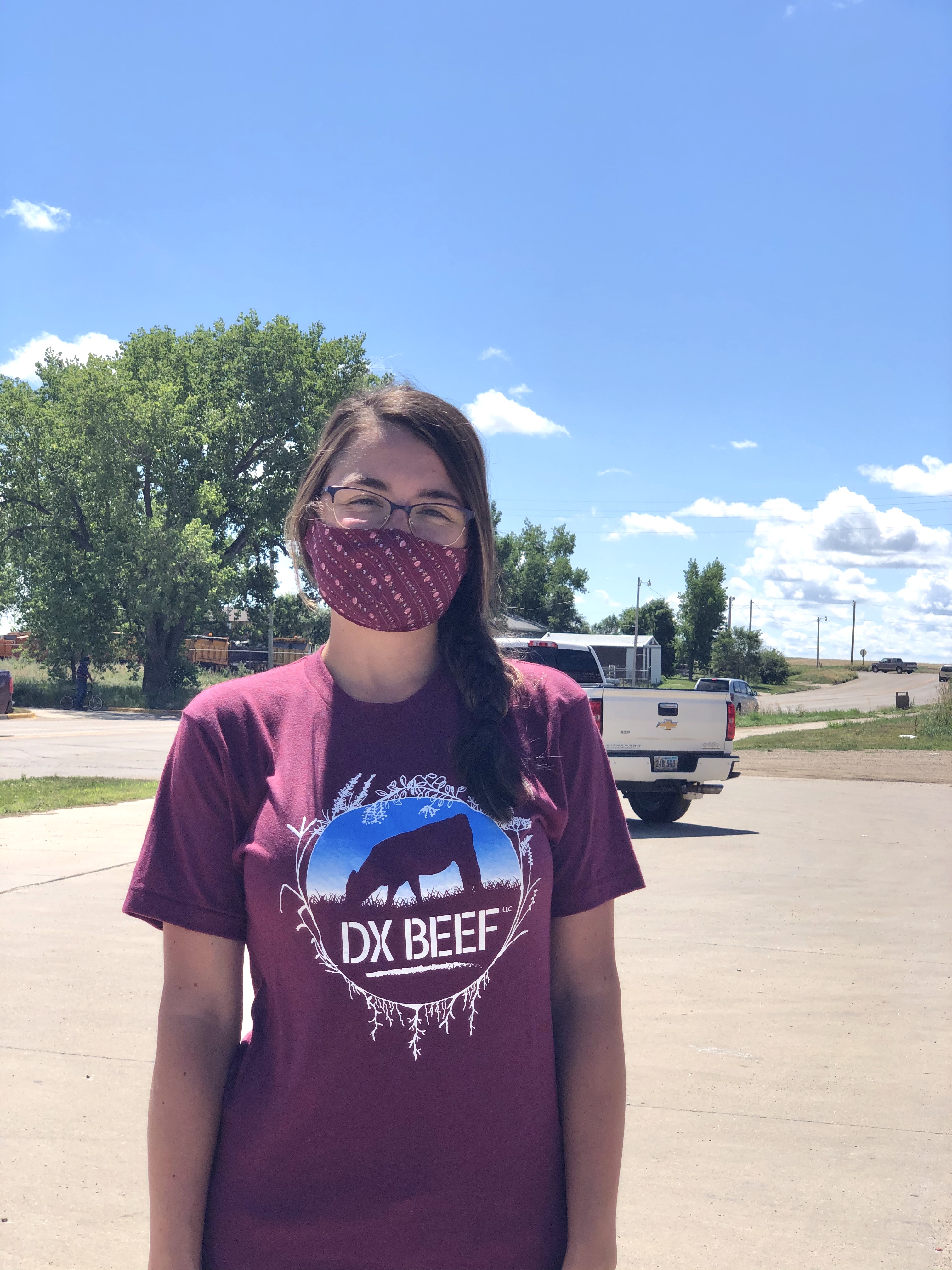 White female in a maroon 'DX Beef' shirt and matching facemask